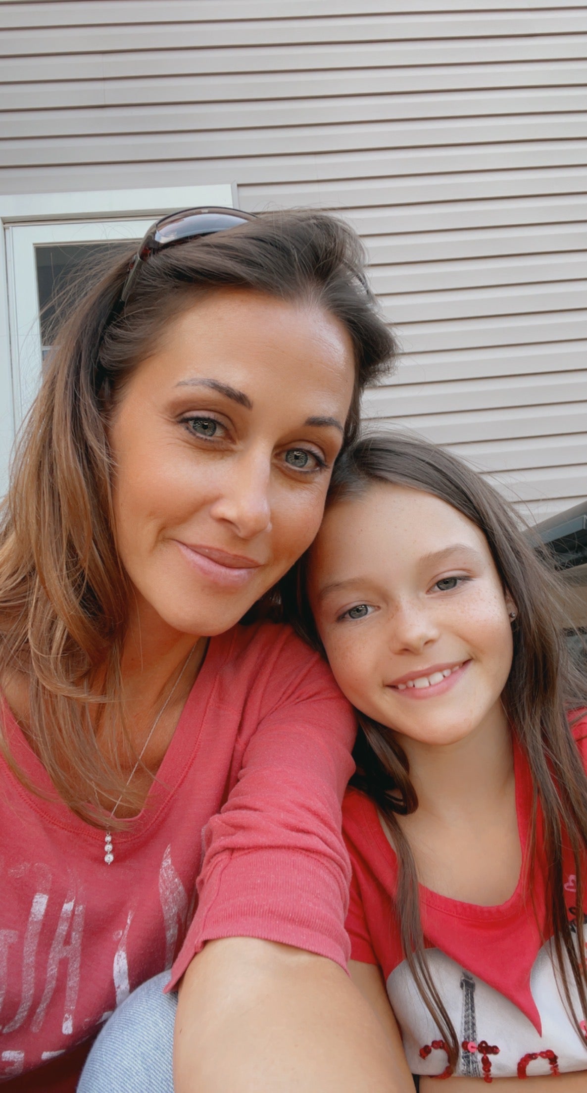 Woman and young girl posing together outdoors