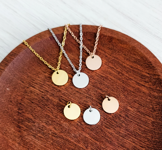 Three necklaces with round pendants on a wooden surface