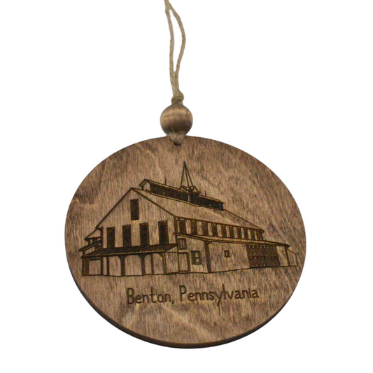 Wooden round ornament with engraved building and 'Benton, Pennsylvania' text on a white background