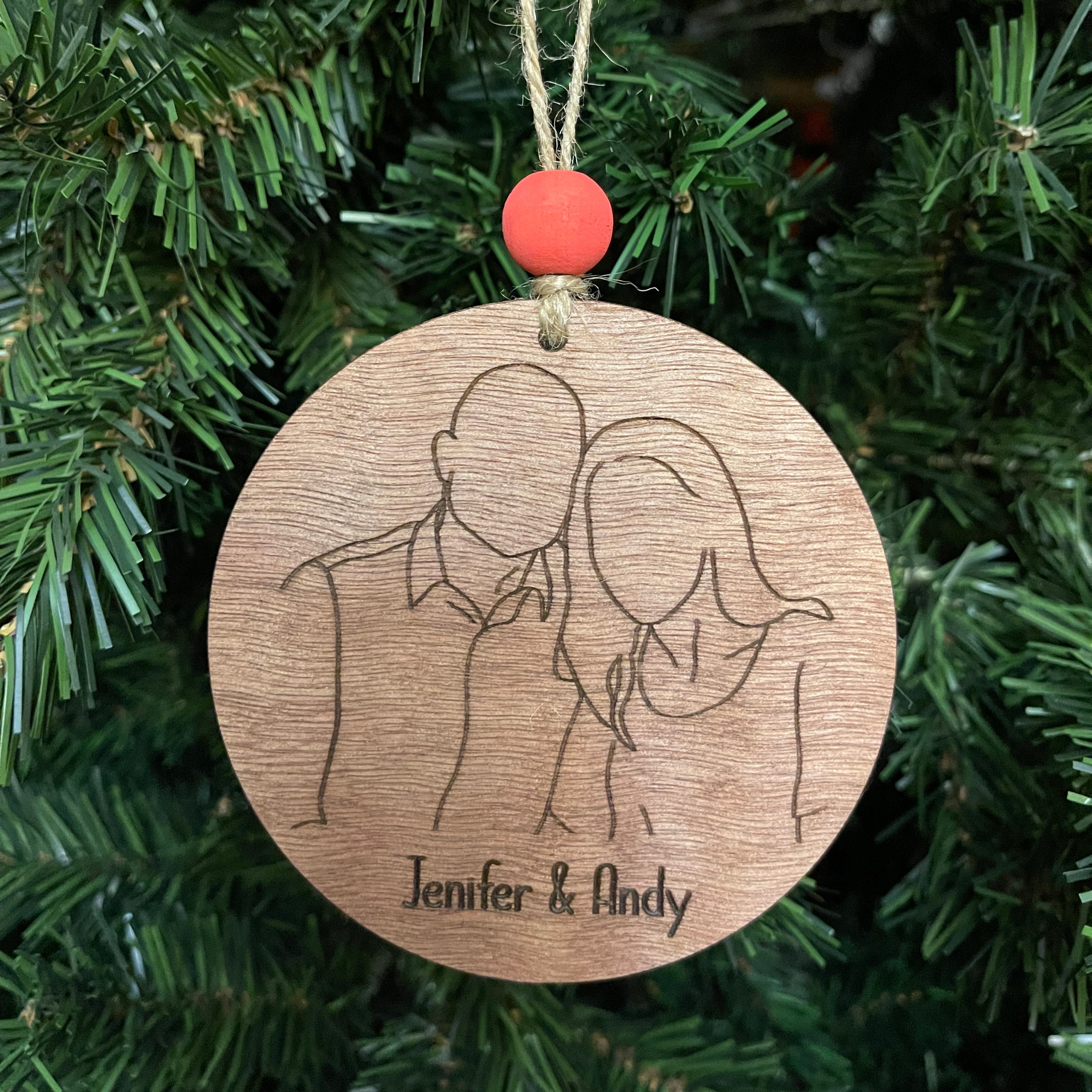 Wooden ornament with engraved design and text on a Christmas tree