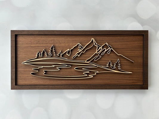 Wooden wall art with mountain and lake design on a textured white background
