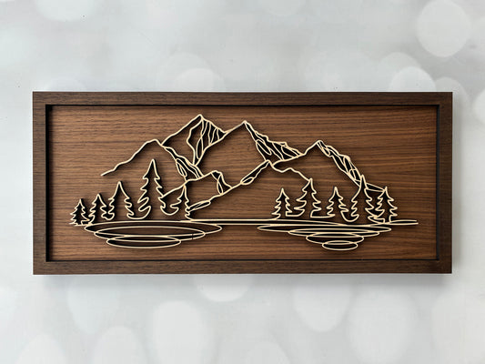 Wooden wall art with mountain and tree design on a textured white background